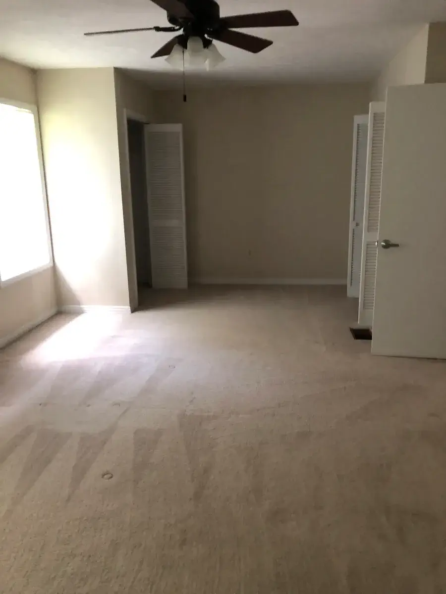 Master bedroom with ceiling fan and two closets