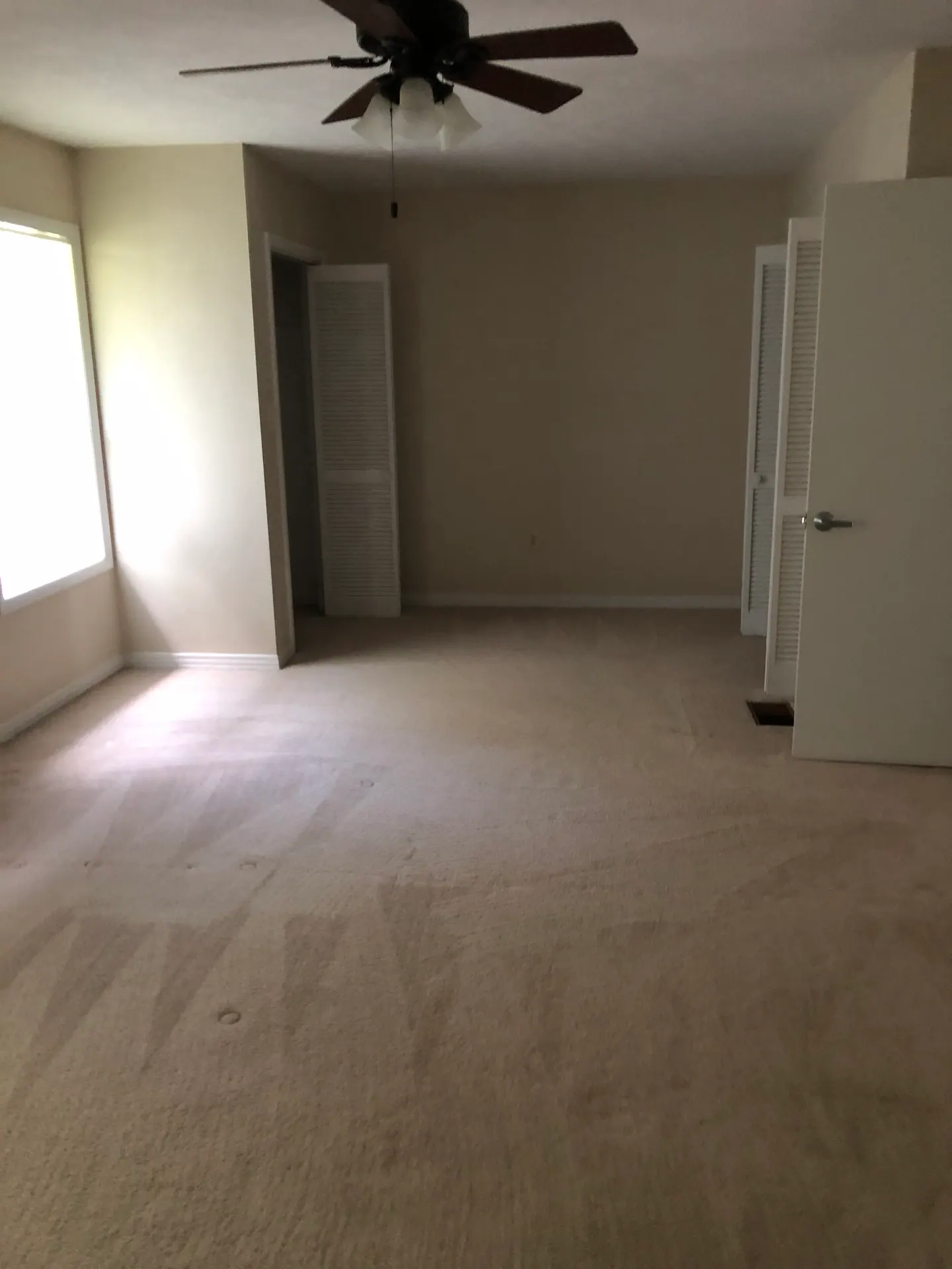 Master bedroom with ceiling fan and two closets