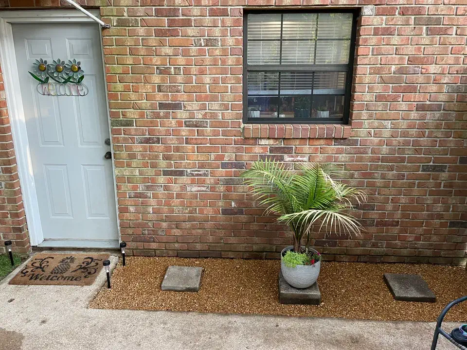 Brick entryway with a white door and welcome mat