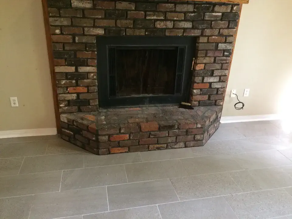 Brick fireplace with hearth on a tiled floor