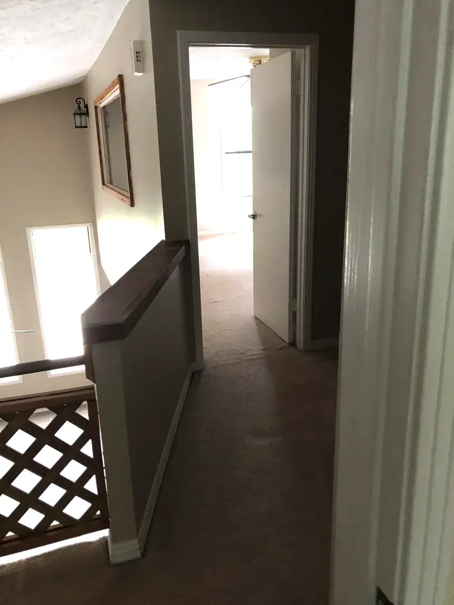 Upstairs hallway with wood railing, looking into the guest bedroom