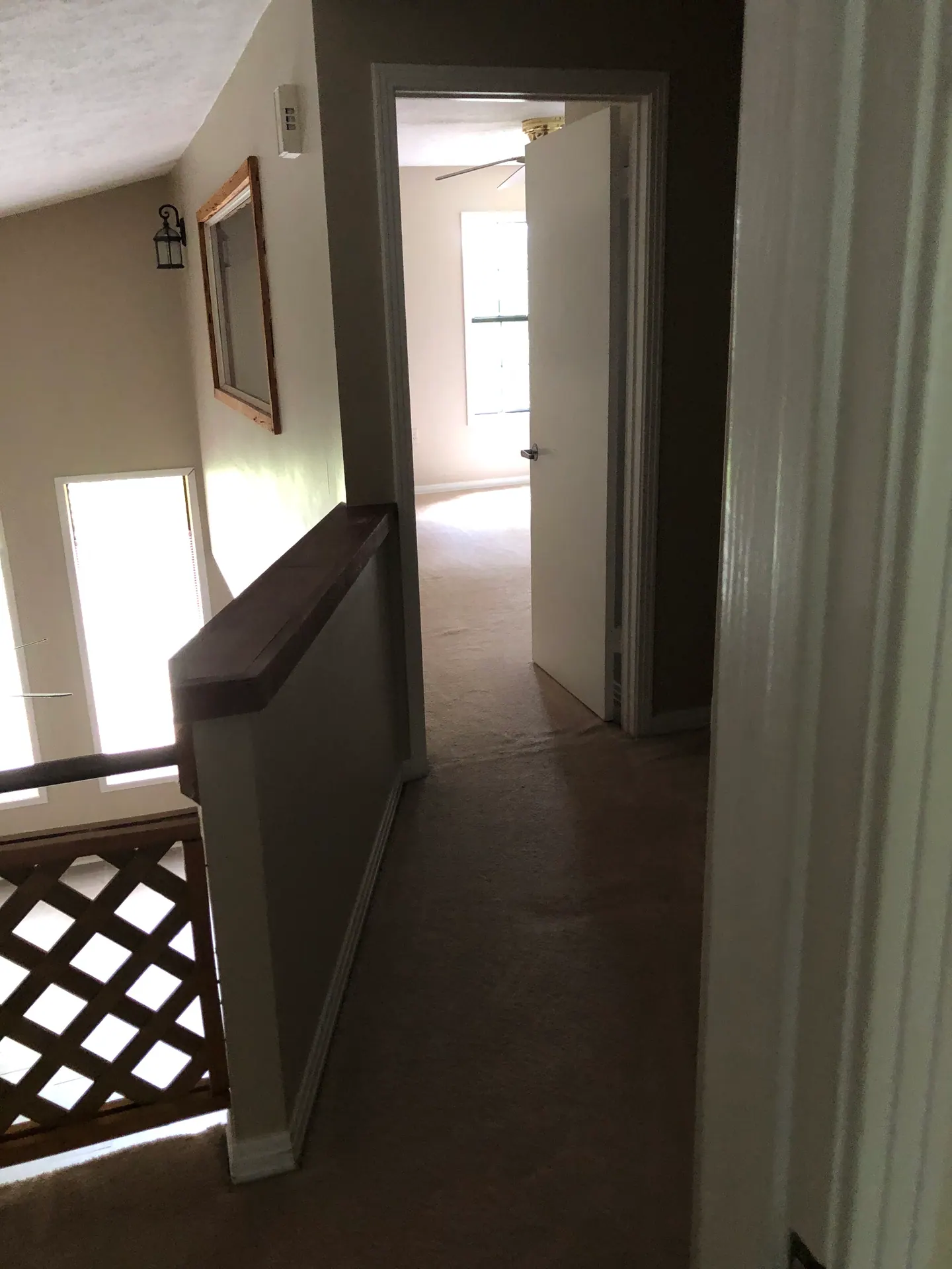 Upstairs hallway with wood railing, looking into the guest bedroom