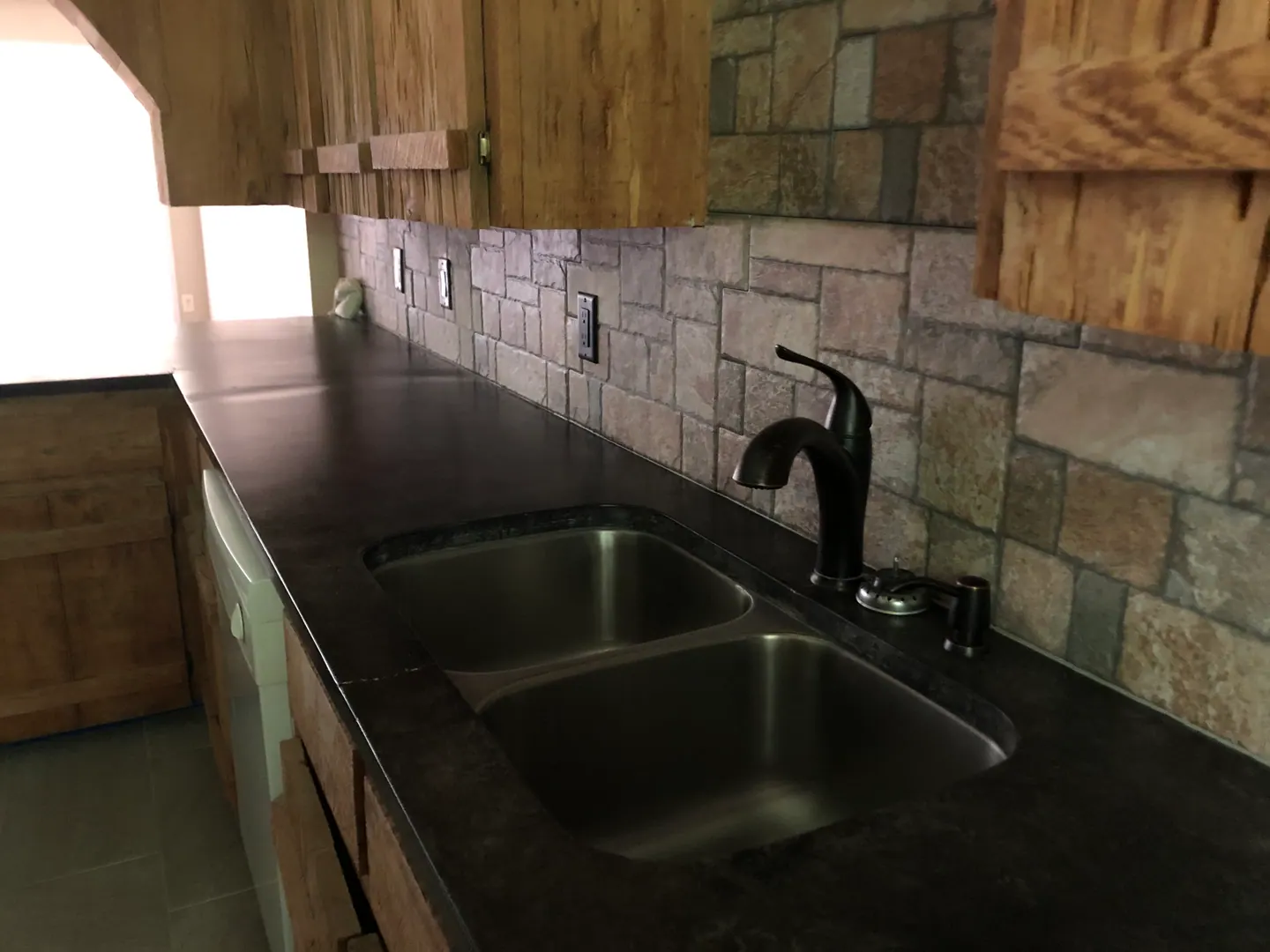 Long stretch of kitchen counter space with wood cabinets