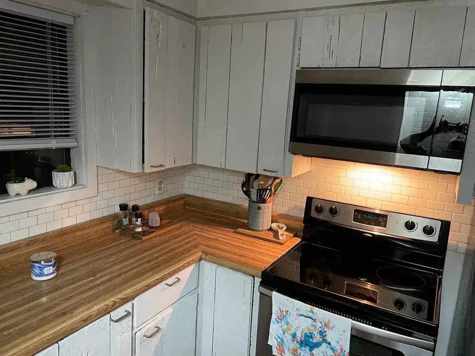 Kitchen with painted cypress cabinets and stainless appliances