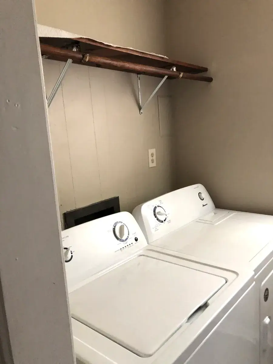 Washer and dryer in the laundry room, with shelving