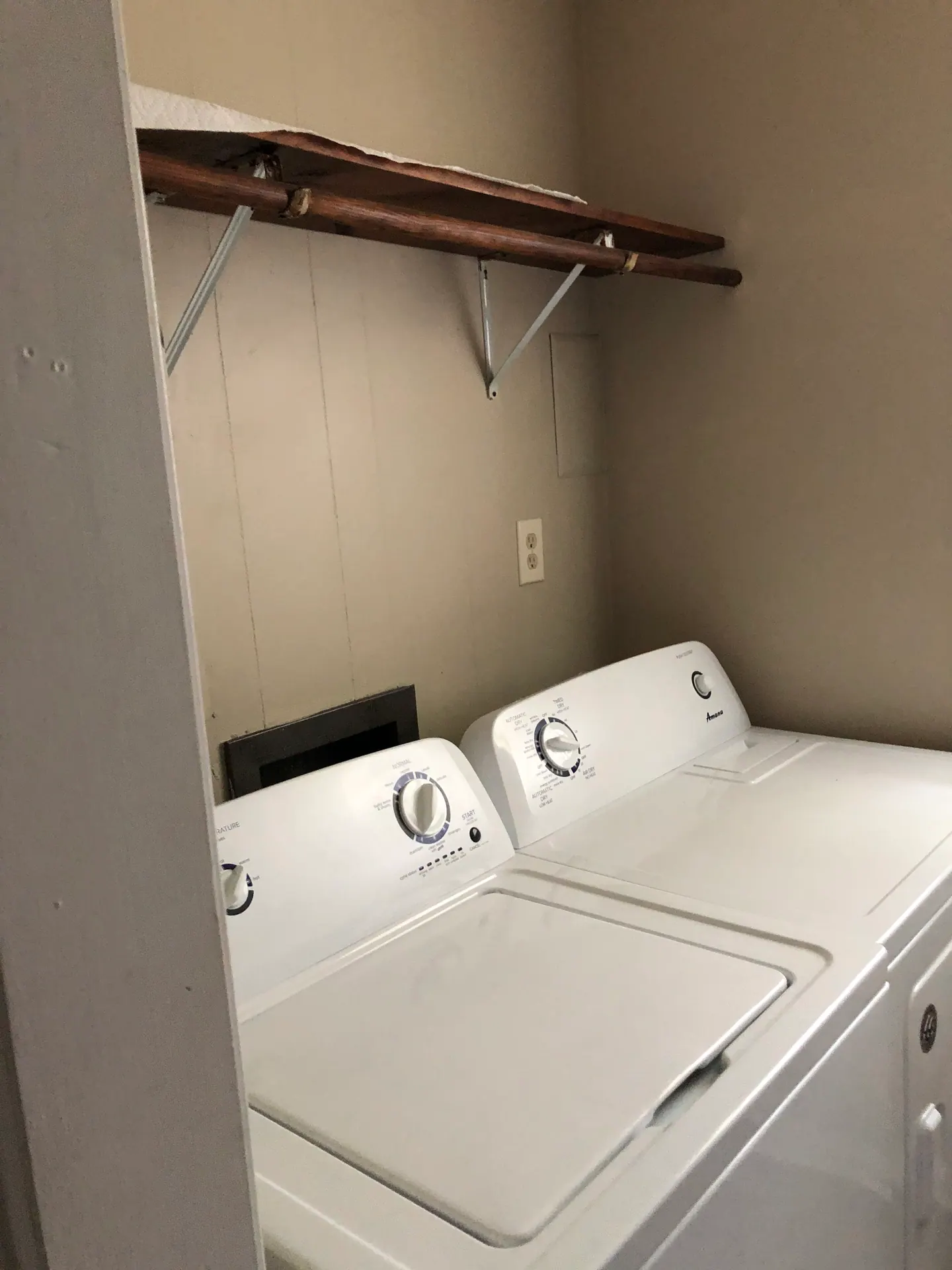 Washer and dryer in the laundry room, with shelving