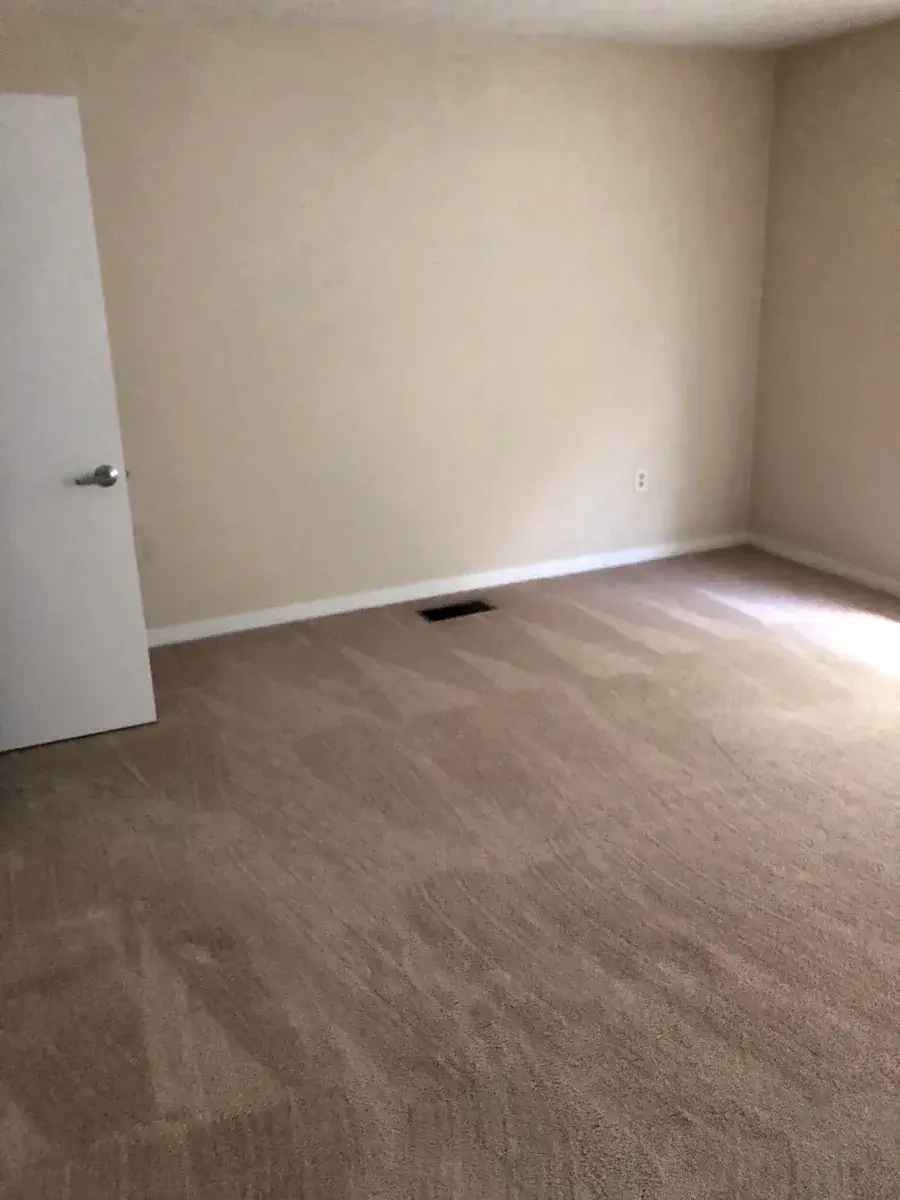 The other half of the master bedroom, with carpet and a window