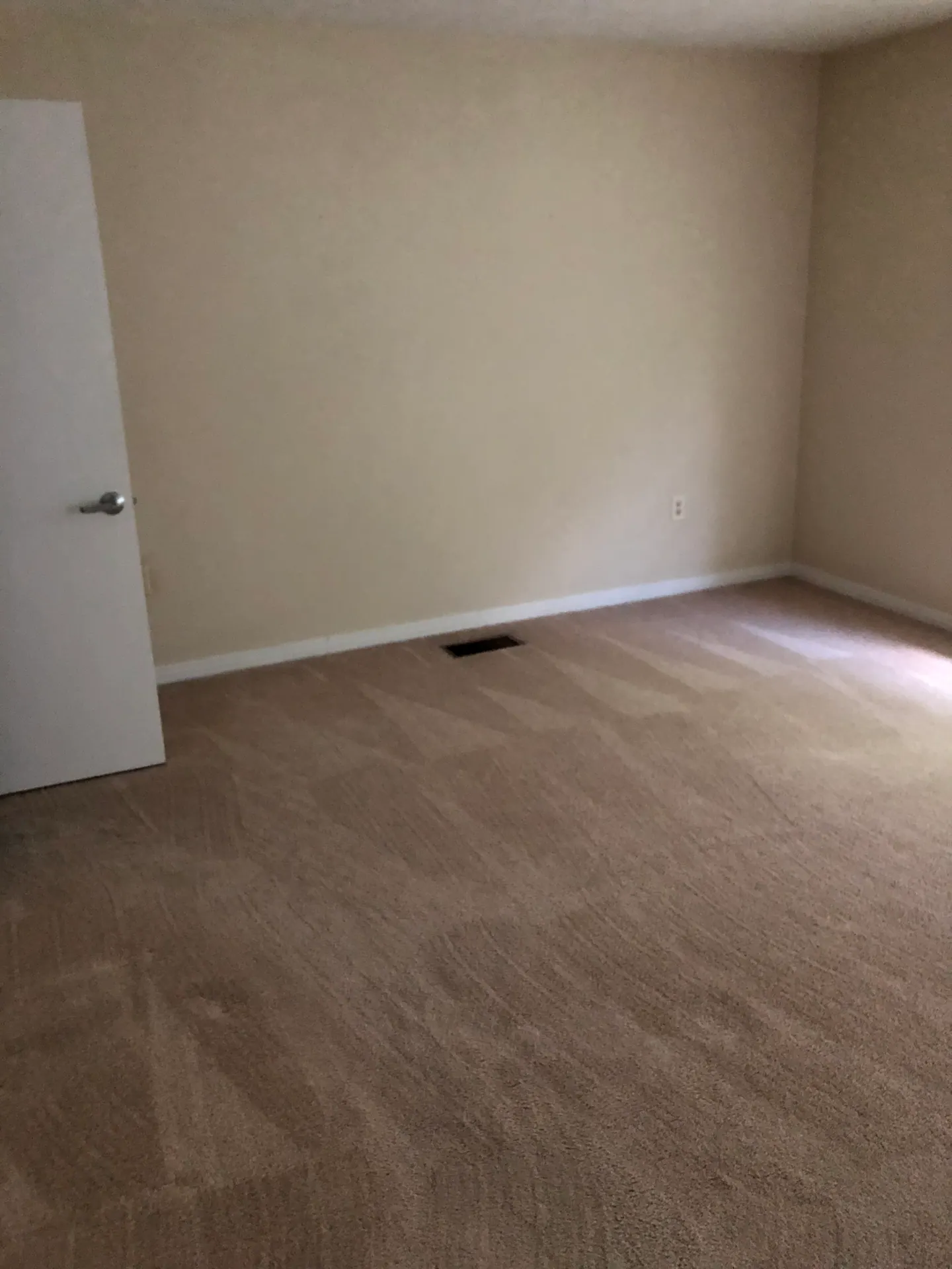 The other half of the master bedroom, with carpet and a window