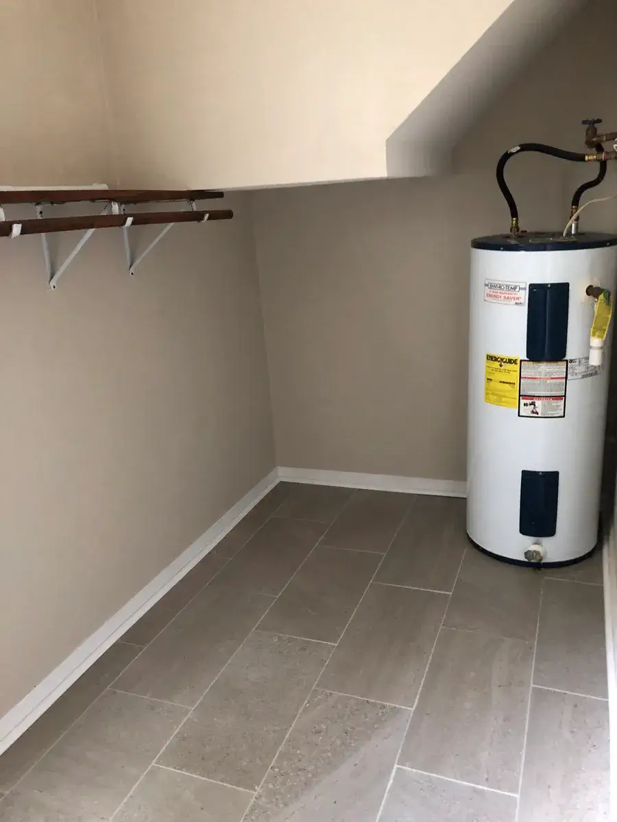 Utility side of the large laundry room, with shelving and water heater