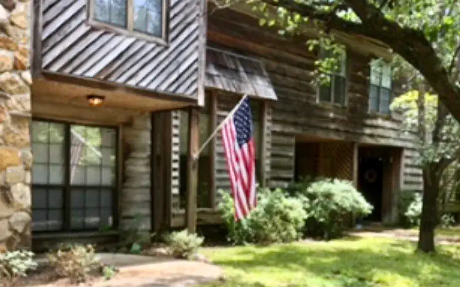Stone and cedar townhomes at Stonington under mature trees, with an American flag by one front porch
